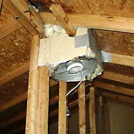 Here, a gable mount exhaust fan was installed directly through the roof. They used drywall board, fiberglass insulation, sheet metal, and duct tape to close the hole. From the looks of the wood rot next to the fan, they will need a new roof very soon.